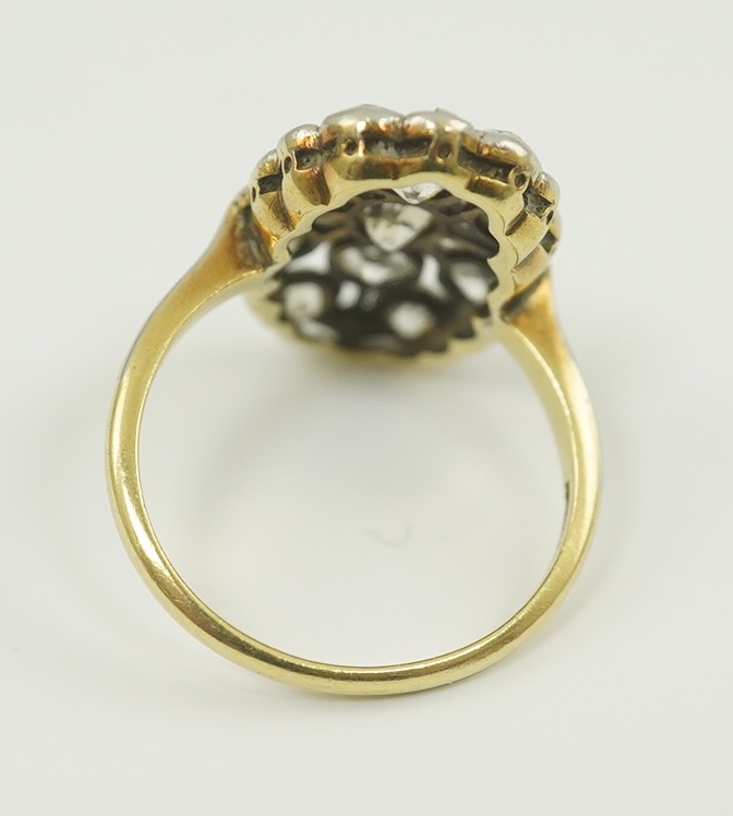 A 1940's 18ct gold, platinum and millegrain set diamond oval cluster ring